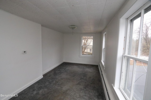 unfurnished room with a wealth of natural light, baseboard heating, and dark carpet