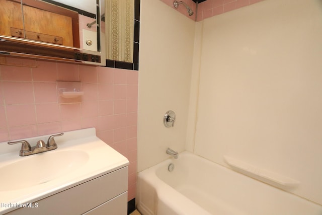 bathroom featuring tile walls, shower / washtub combination, and vanity