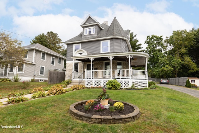 victorian home with a porch and a front yard