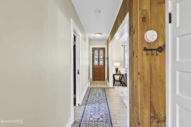 hallway featuring baseboards and light wood-type flooring