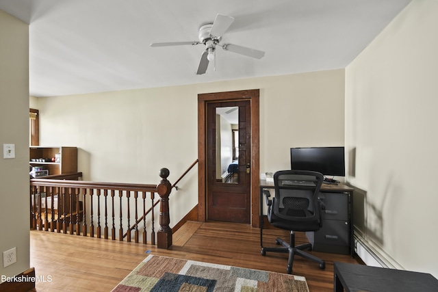 office area with wood finished floors, baseboards, and ceiling fan