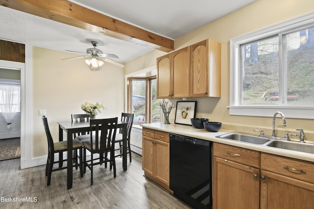 kitchen with a sink, beamed ceiling, light wood-type flooring, and dishwasher