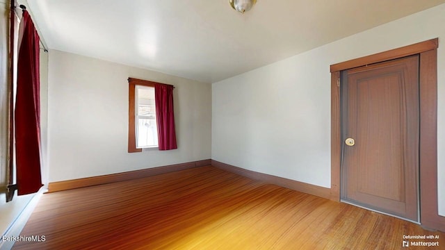 empty room with wood finished floors and baseboards