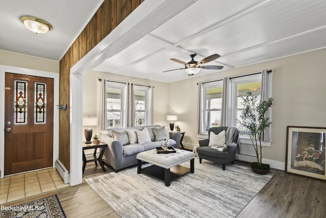 living room with a baseboard radiator, ceiling fan, and wood finished floors