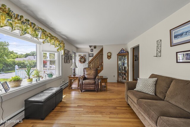 17 Jeffrey Dr, Pittsfield, MA 01201 - living area featuring baseboard heating, light wood finished floors, stairway, and a baseboard radiator