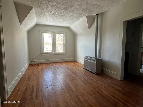 51 Bracewell Ave, North Adams, MA 01247 - additional living space with a textured ceiling, hardwood / wood-style floors, lofted ceiling, and heating unit