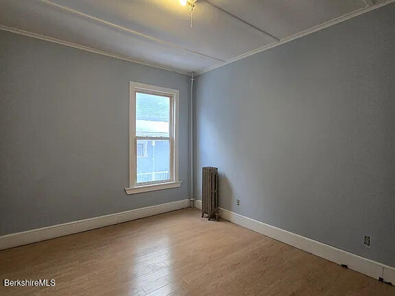 51 Bracewell Ave, North Adams, MA 01247 - unfurnished room featuring radiator heating unit, ornamental molding, and wood finished floors