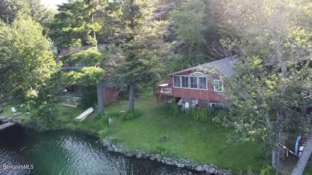 drone / aerial view featuring a water view and a wooded view