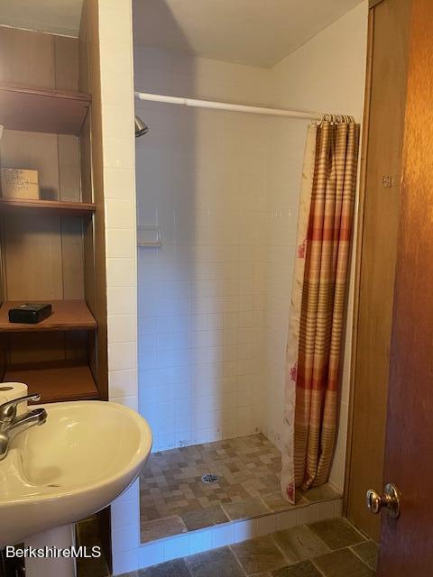 full bath with a sink and a stall shower