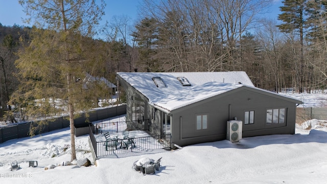 view of snowy exterior with fence and a patio