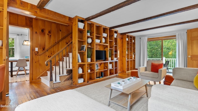 76 New Lenox Rd, Lenox, MA 01240 - living area featuring beamed ceiling, healthy amount of natural light, wood-type flooring, stairs, and wooden walls