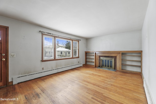 unfurnished living room with baseboard heating, a fireplace, and light hardwood / wood-style floors