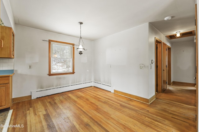 unfurnished dining area featuring hardwood / wood-style flooring and a baseboard radiator