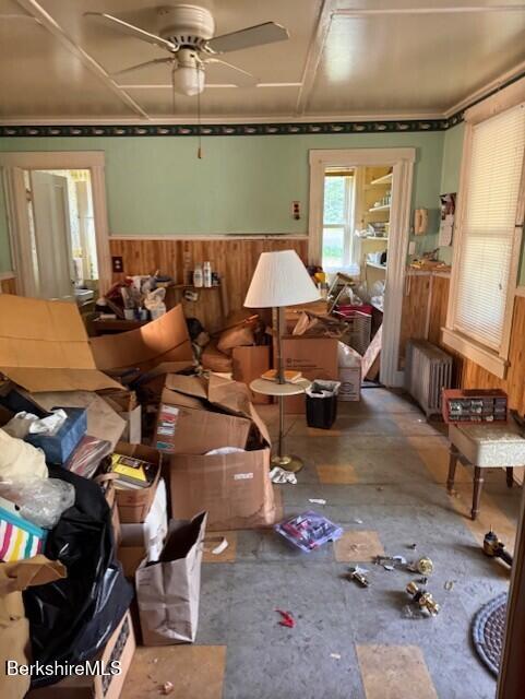 9 Anthony St, Adams, MA 01220 - living area with radiator, wainscoting, wood walls, and a ceiling fan