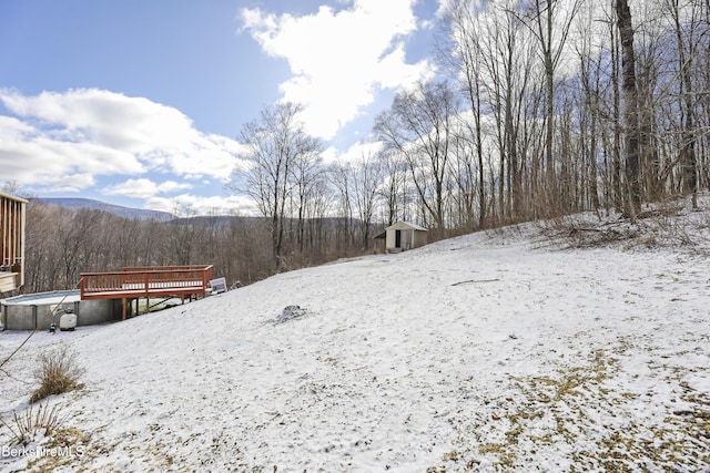 yard layered in snow featuring a deck