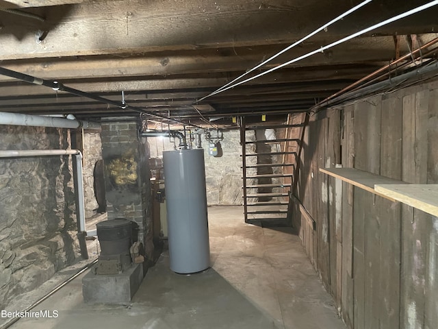 unfinished below grade area featuring gas water heater and a wood stove