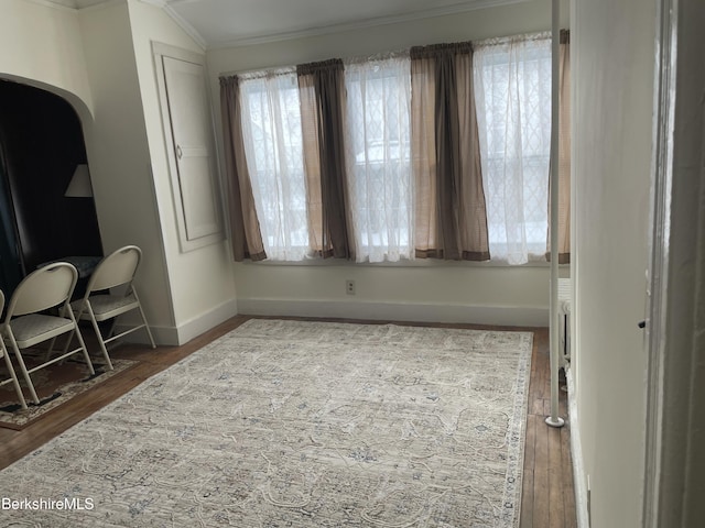 bedroom featuring baseboards, lofted ceiling, crown molding, and hardwood / wood-style flooring