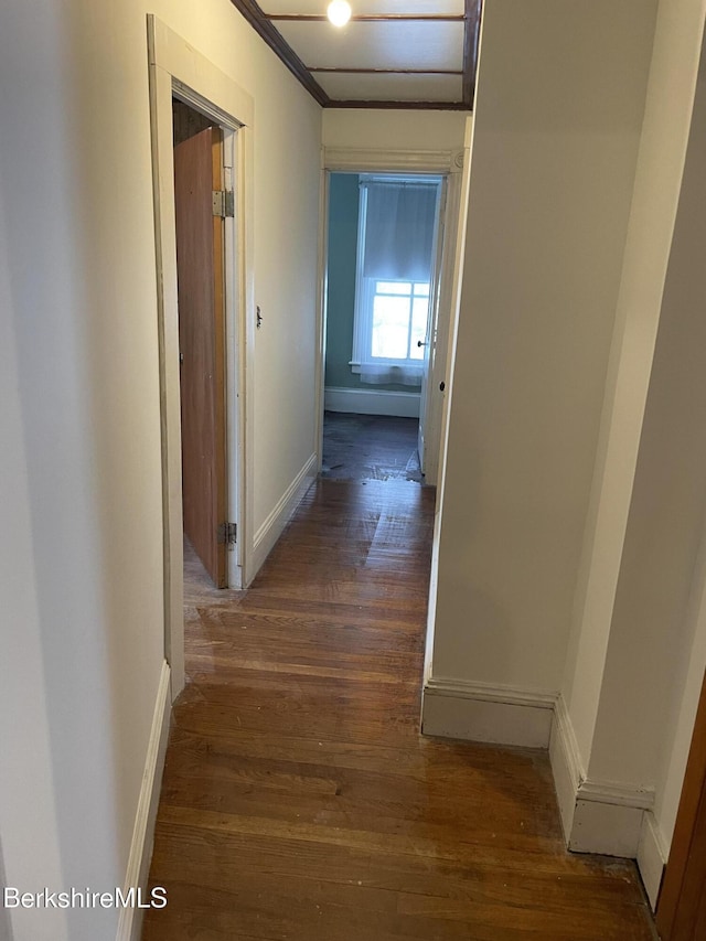 hallway with baseboards and wood finished floors