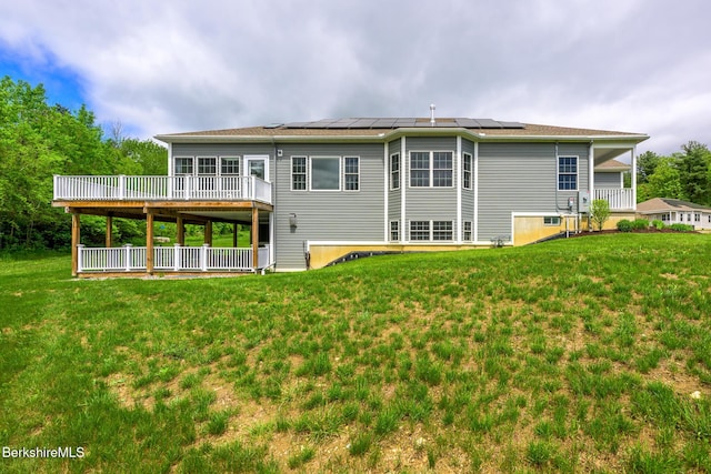 19 Aspen Way, Pittsfield, MA 01201 - rear view of house featuring a deck, a lawn, and roof mounted solar panels
