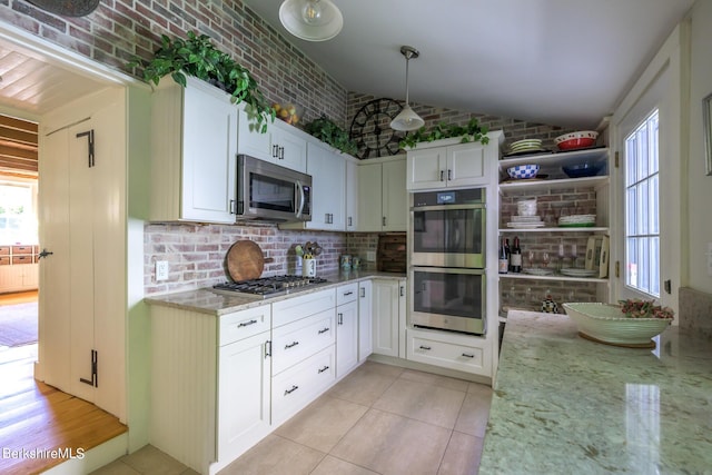 85 E Main St, Stockbridge, MA 01262 - kitchen featuring appliances with stainless steel finishes, light stone counters, decorative backsplash, vaulted ceiling, and light tile patterned floors