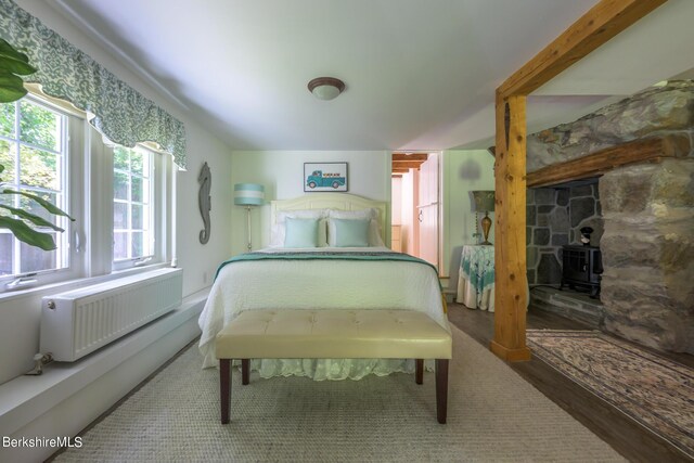 85 E Main St, Stockbridge, MA 01262 - bedroom with radiator heating unit, multiple windows, wood finished floors, and a wood stove