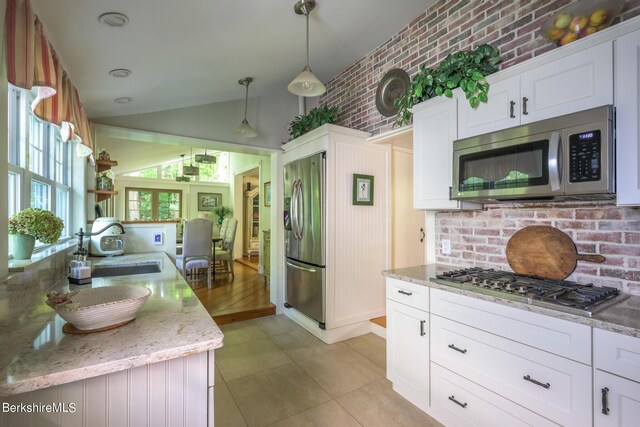 85 E Main St, Stockbridge, MA 01262 - kitchen with stainless steel appliances, a sink, lofted ceiling, white cabinets, and light stone countertops
