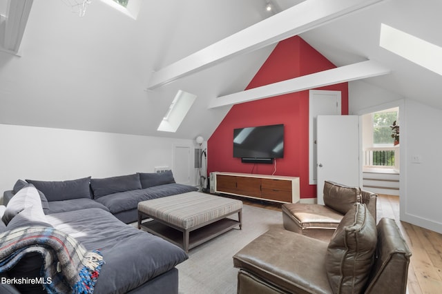 living area with vaulted ceiling with skylight and wood finished floors