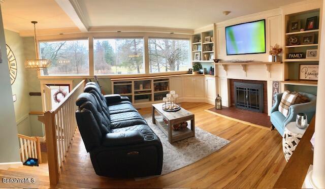 living room with built in features and light hardwood / wood-style flooring