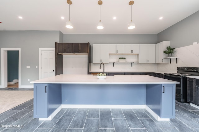 138 Ridge Rd, Worthington, MA 01098 - kitchen with electric range, open shelves, light countertops, white cabinets, and a spacious island
