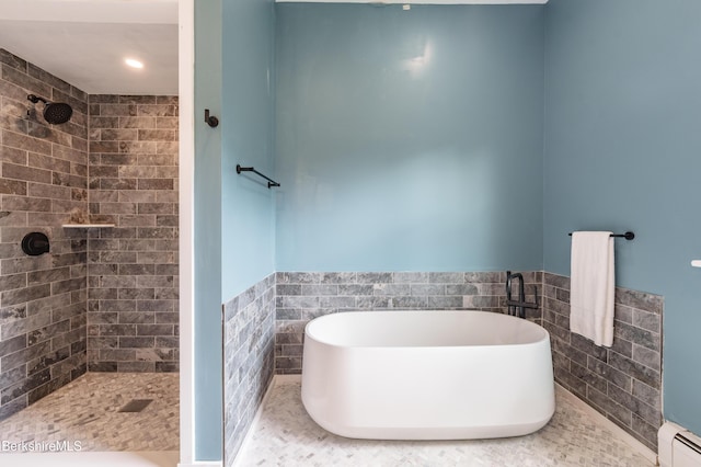 138 Ridge Rd, Worthington, MA 01098 - bathroom featuring a baseboard radiator, tile walls, tiled shower, a freestanding bath, and a wainscoted wall