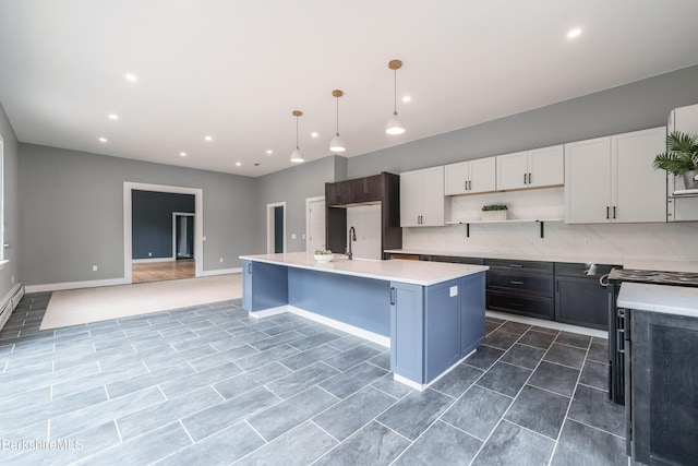 138 Ridge Rd, Worthington, MA 01098 - kitchen with open shelves, light countertops, an island with sink, decorative backsplash, and recessed lighting