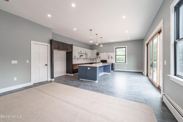 138 Ridge Rd, Worthington, MA 01098 - kitchen with baseboard heating, light countertops, a kitchen island with sink, recessed lighting, and a baseboard radiator