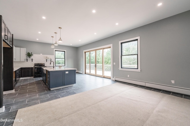 138 Ridge Rd, Worthington, MA 01098 - kitchen with stove, light countertops, recessed lighting, a baseboard radiator, and an island with sink