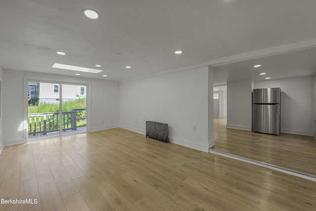 102 Pontoosuc Ave, Pittsfield, MA 01201 - empty room featuring a skylight, radiator heating unit, recessed lighting, and light wood-style floors