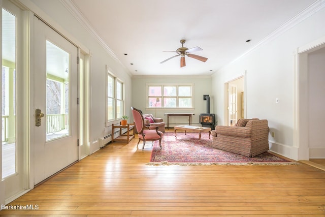 5 Stockbridge Rd, West Stockbridge, MA 01266 - living area with a wood stove, light wood-style flooring, crown molding, ceiling fan, and a baseboard radiator
