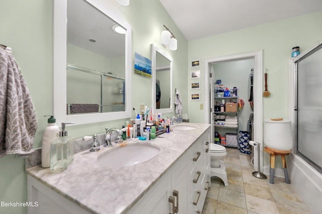 full bath with double vanity, toilet, and a sink