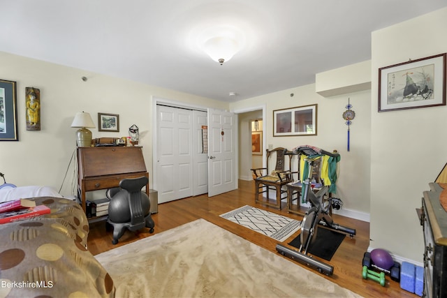 exercise area featuring baseboards and wood finished floors