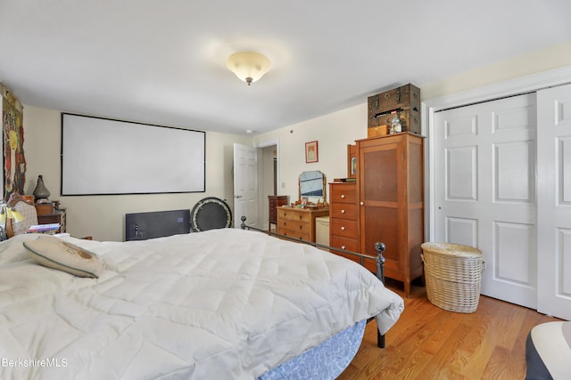 bedroom with light wood finished floors and a closet