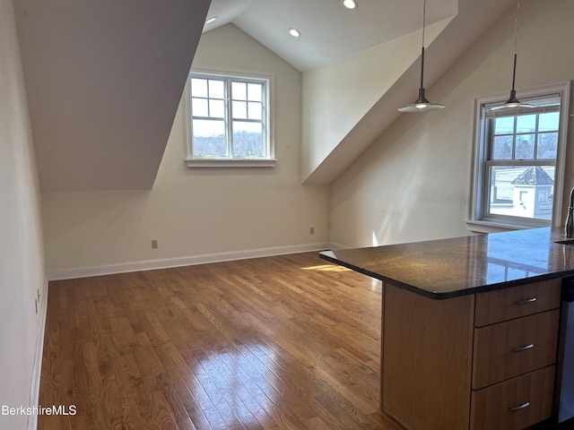 bonus room featuring baseboards, vaulted ceiling, wood finished floors, and a healthy amount of sunlight