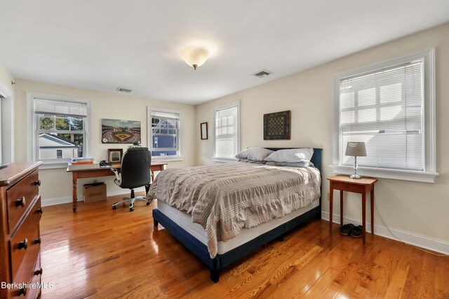 bedroom featuring visible vents, baseboards, and light wood-style flooring