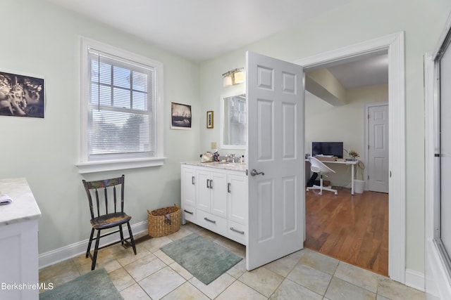 bathroom with tile patterned flooring, vanity, and baseboards