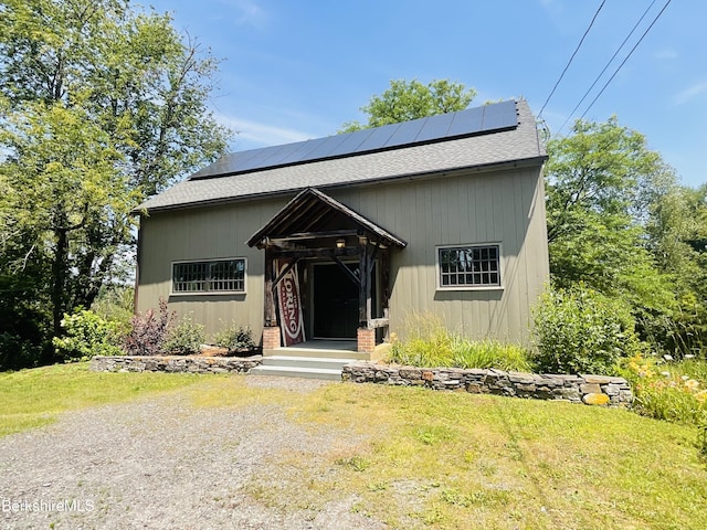 view of front of house featuring a front lawn and solar panels