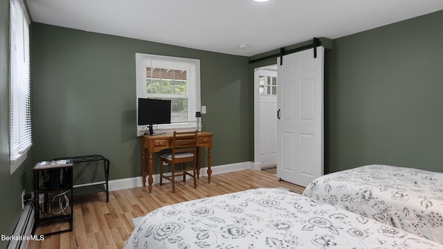 207 S Mountain Rd, Pittsfield, MA 01201 - bedroom featuring a barn door, light wood-type flooring, and baseboards