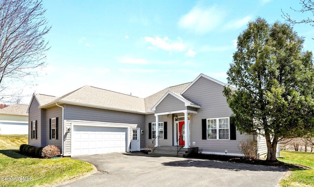 view of front of house featuring a garage, a shingled roof, a front lawn, and aphalt driveway