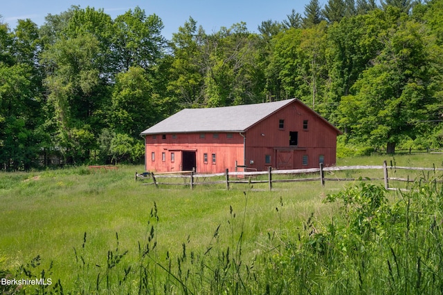 28 Main Rd, Tyringham, MA 01264 - view of yard with a detached garage, a barn, an outbuilding, and a wooded view