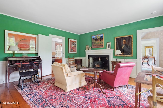 28 Main Rd, Tyringham, MA 01264 - living room with wood finished floors, crown molding, wainscoting, and a wood stove