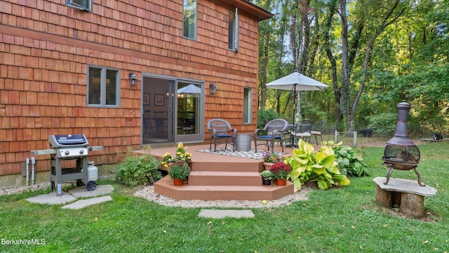 back of house featuring a lawn and a wooden deck