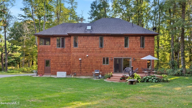 rear view of property featuring a wooden deck and a lawn