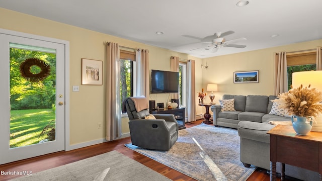 living room with dark hardwood / wood-style floors and ceiling fan