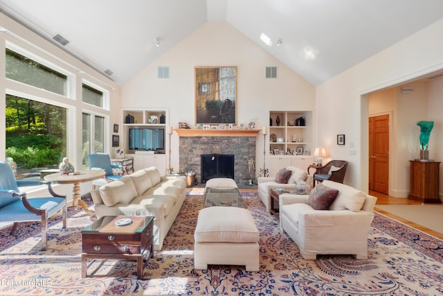 living room featuring a stone fireplace, light hardwood / wood-style flooring, and vaulted ceiling